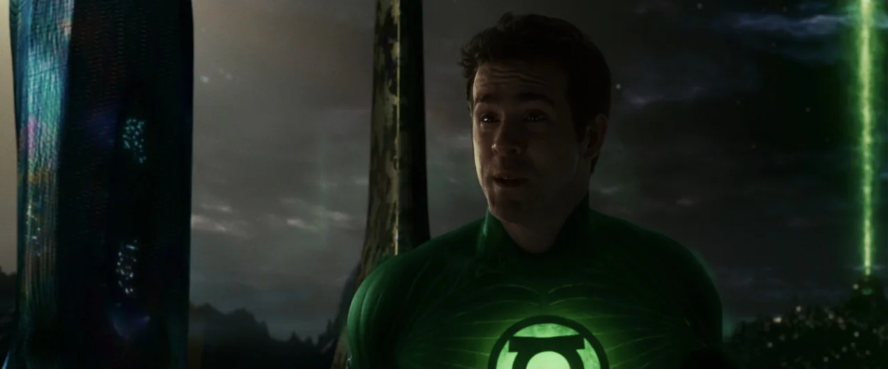 Green Lantern (2011) movie still: medium — A dark alien landscape features tall, obsidian-like monoliths against a clouded night sky. A man in a…