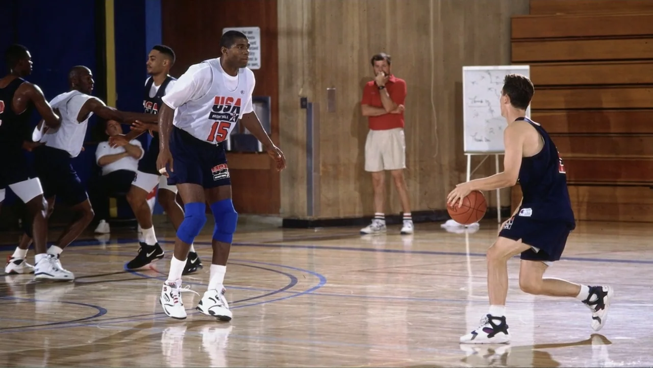 We Beat the Dream Team (2025) movie still: fullbody — An indoor basketball court with wooden floors and bleachers in the background. A player in a…