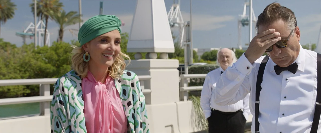 Father of the Bride (1991) movie still: medium — A bright outdoor concrete bridge on a sunny day with palm trees in view. A blonde woman smiles as a…