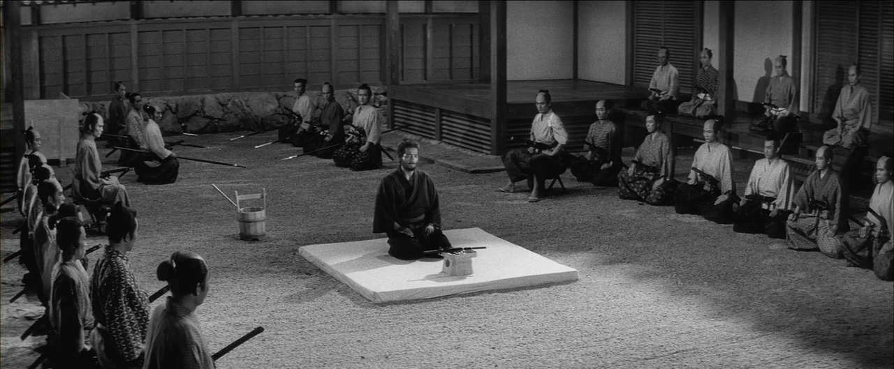 Harakiri (1962) movie still: wide — A traditional Japanese courtyard features a gravel ground and wooden architecture in the background. A man…
