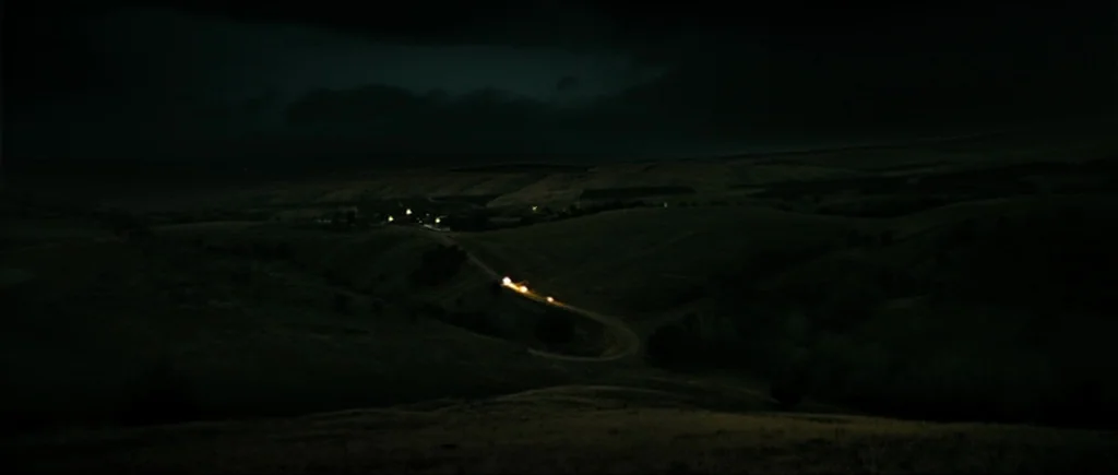 Once Upon a Time in Anatolia (2011) movie still: establishing — Rolling hills stretch under a dark, overcast night sky with minimal illumination. A…
