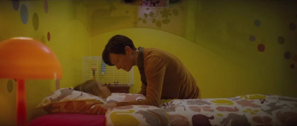 We Need To Talk About Kevin (2011) movie still: medium — A brightly colored yellow room features walls decorated with dark circular patterns. A…