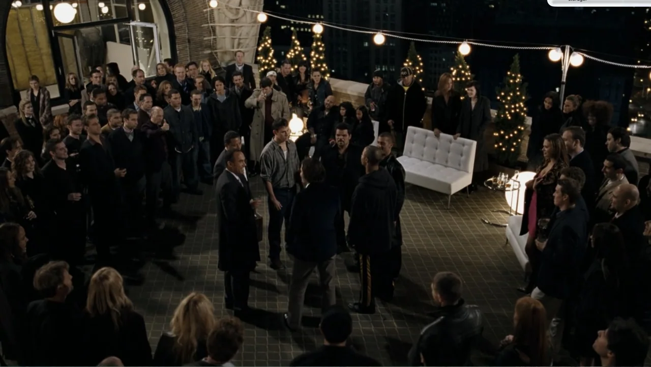 Fighting (2009) movie still: wide — A high-angle view of a populated rooftop terrace at night with string lights. A large crowd of well-dressed…