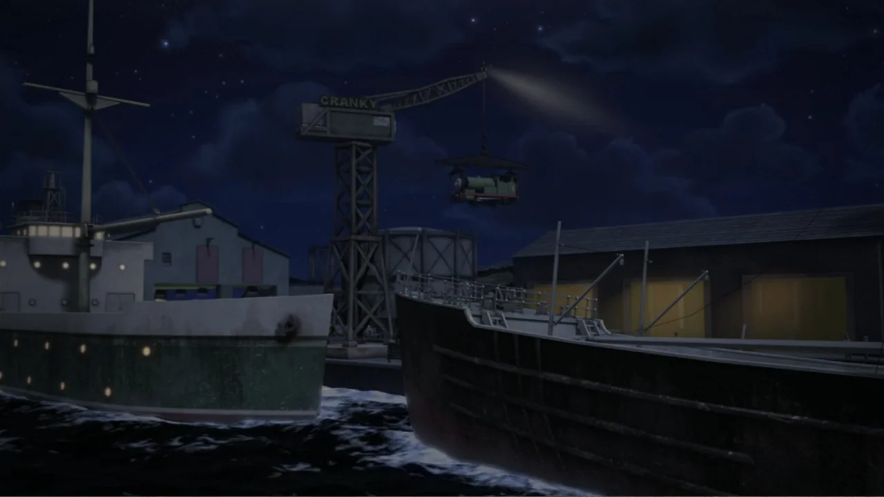 Thomas & Friends: Tale of the Brave (2014) movie still: wide — A nighttime industrial harbor shows two cargo ships moored at a dark stone wharf. A…