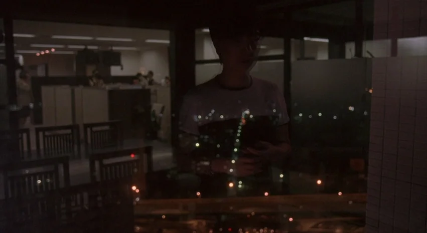 Yi-Yi (A One and A Two) (2000) movie still: medium — A dark, modern interior space features a glass partition reflecting city lights outside. A…