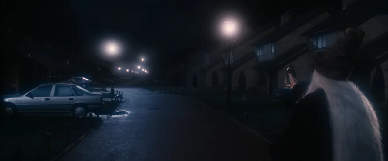 Harry Potter and the Philosopher's Stone (2001) movie still: medium — A quiet residential street at night is lined with terraced houses and parked…