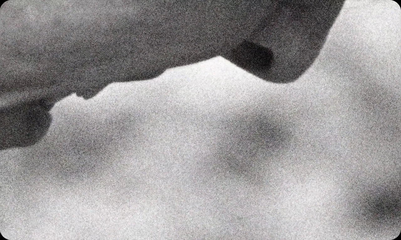Vulcanizadora (2024) movie still: closeup — An abstract, high-contrast black and white frame showing a sharp division of light. A dark amorphous…