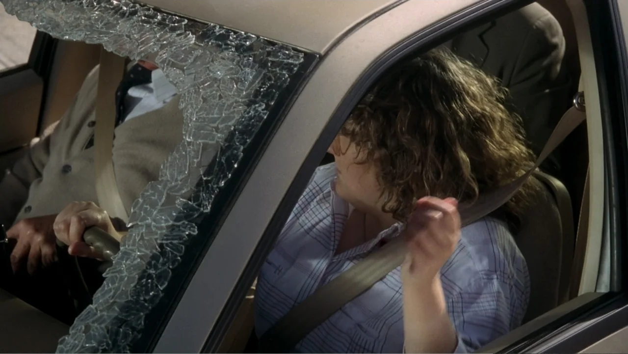 The Naked Gun: From the Files of Police Squad! (1988) movie still: medium — A vehicle interior features a cracked windshield and two passengers in…