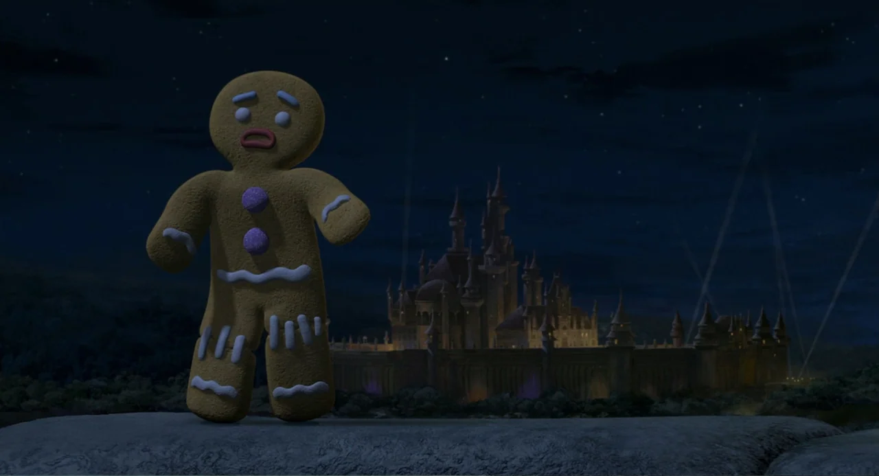 Shrek 2 (2004) movie still: fullbody — A gingerbread man stands on a dark, rocky cliff under a night sky. In the background, a large illuminated…