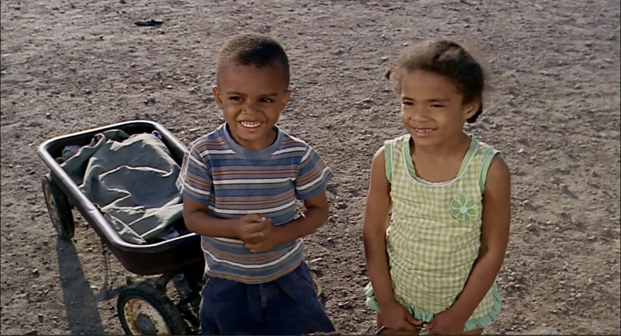 In the Heat of the Night (1967) movie still: medium — A dry, dirt-covered lot serves as the setting for two young children. The children stand near…