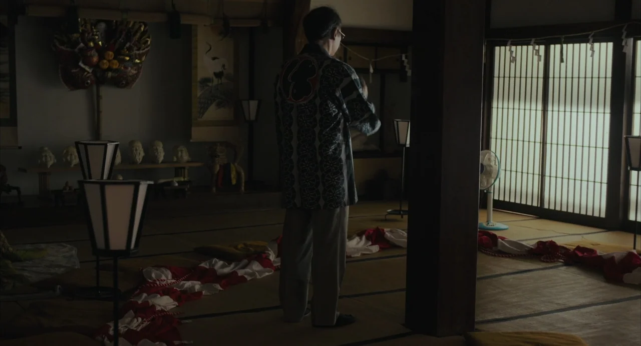 Stigmatized Properties: Possession (2025) movie still: fullbody — A traditional tatami-matted room features paper sliding screens and assorted…