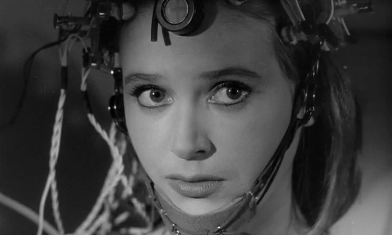 Eyes Without A Face (1960) movie still: closeup — A close-up shot focuses on a young woman inside a scientific or medical laboratory. She wears a…