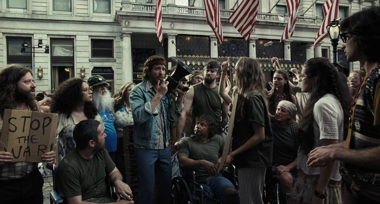 The Post (2017) movie still: medium — An urban plaza in front of an neoclassical building is decorated with many American flags. A group of…