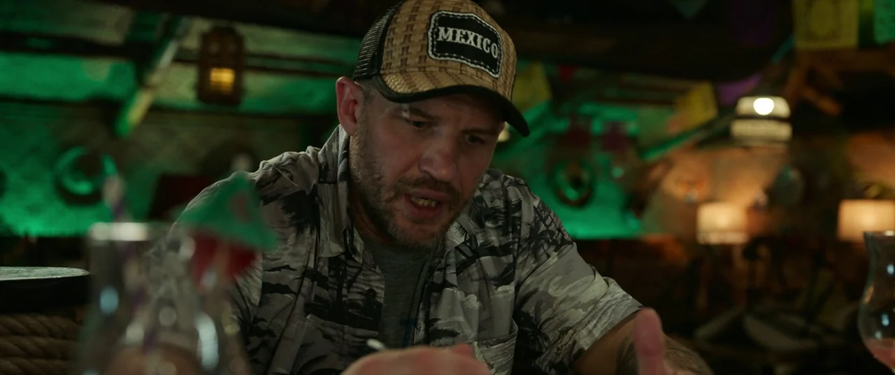 Spider-Man: No Way Home (2021) movie still: medium — A dimly lit tropical-themed bar interior features dark wood decor and green neon lights. A man…