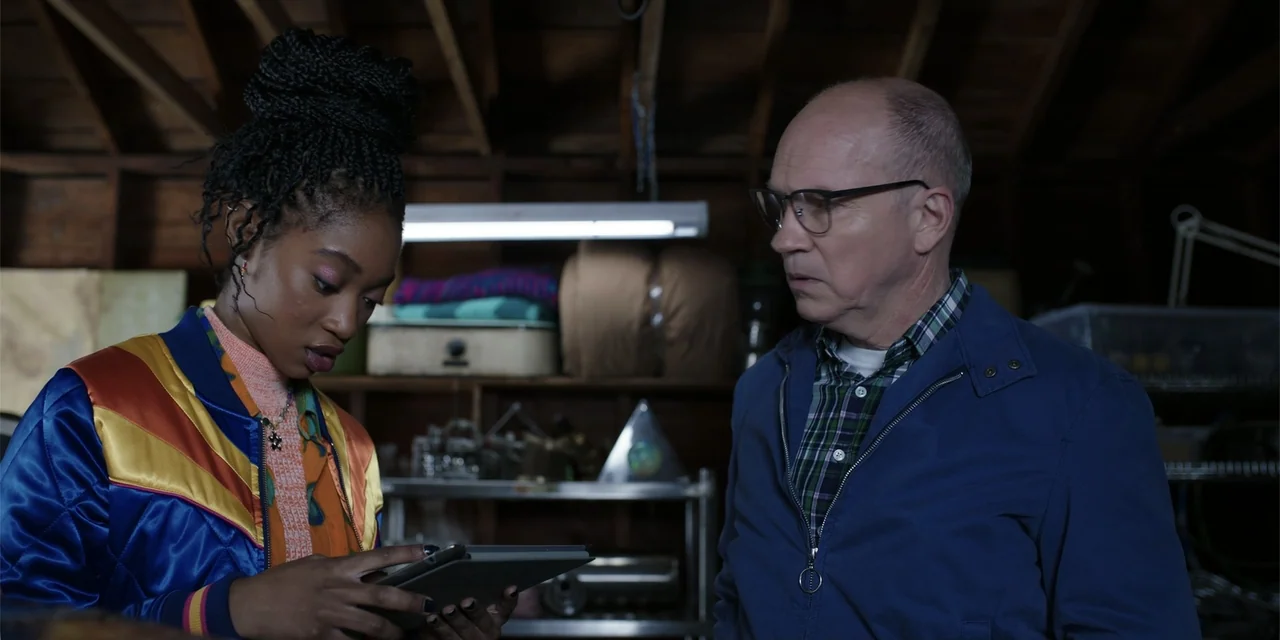 Totally Killer (2023) movie still: medium — A cluttered garage interior contains shelves filled with assorted objects and equipment. A young woman…