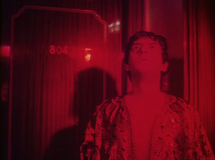 Hermitage (1968) movie still: medium — A dark hotel hallway features a wooden door with the gold numbers 804 mounted. A man stands in the hallway…