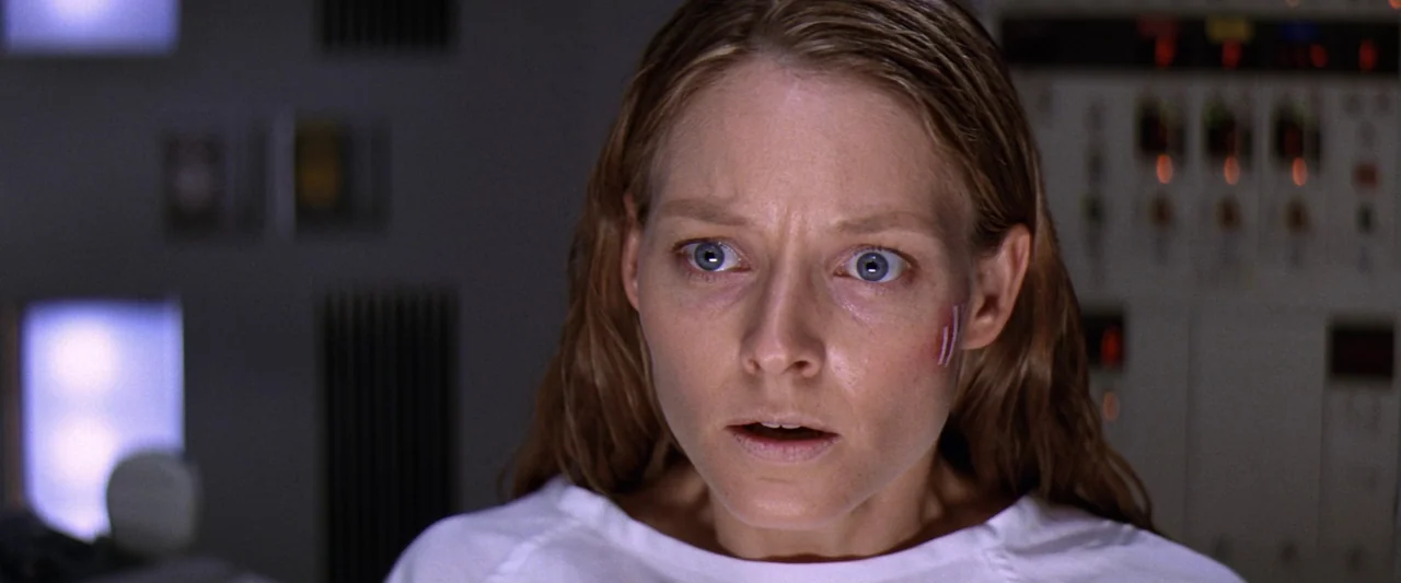 Contact (1997) movie still: closeup — A sterile laboratory setting features a complex control panel with illuminated indicator lights. A woman…