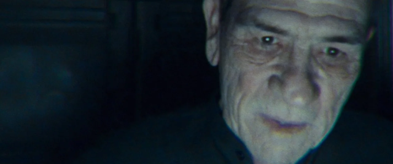 Ad Astra (2019) movie still: closeup — An older man sits in a pitch-black environment with minimal ambient illumination. He faces toward the side…
