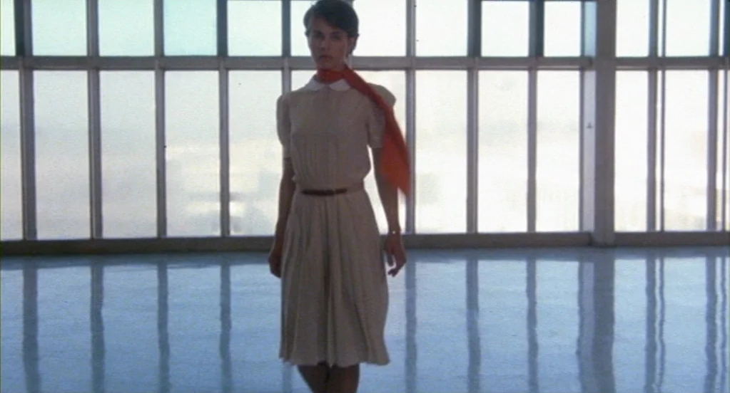 Cat People (1982) movie still: fullbody — A spacious office interior features large floor-to-ceiling windows with a bright white view outside. A…