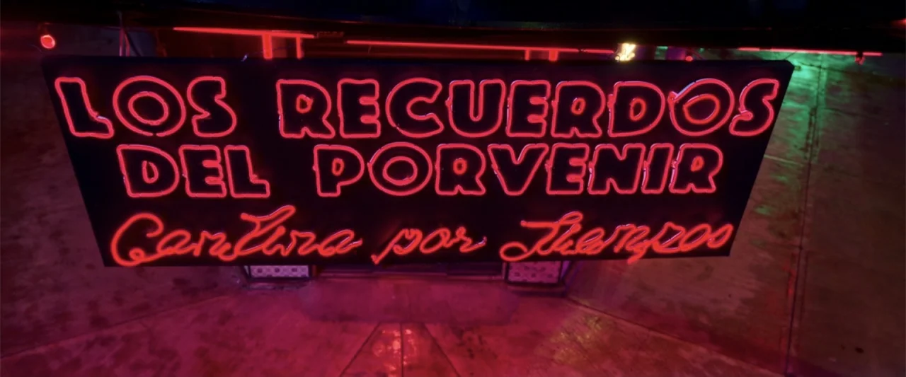 Tequila Re-Pasado (2023) movie still: medium — A black signboard with red neon text hangs above a dim entrance at night. The sign reads Los…