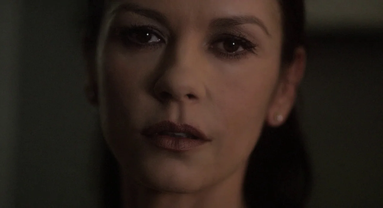 Side Effects (2013) movie still: closeup — A dimly lit indoor space with an out-of-focus background. A woman looks forward with a steady gaze.