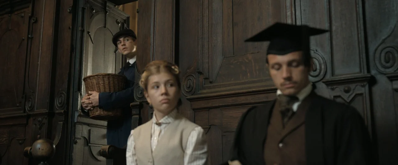 Young Sherlock Holmes (1985) movie still: medium — A wood-paneled interior features intricate dark carvings and historical architectural details.…