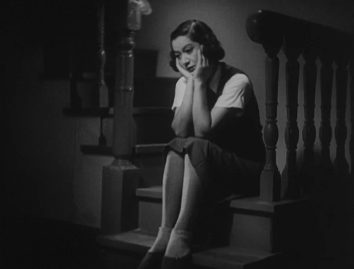 No Regrets for Our Youth (1946) movie still: medium — A woman sits on the dark steps of a wooden staircase indoors at night. She rests her chin on…
