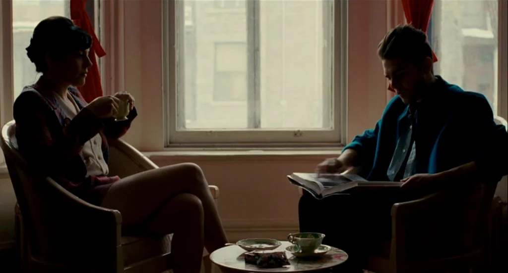 Heartbeats (Les Amours Imaginaires) (2010) movie still: medium — A quiet living room with a large window looking out onto a city street. Two people…