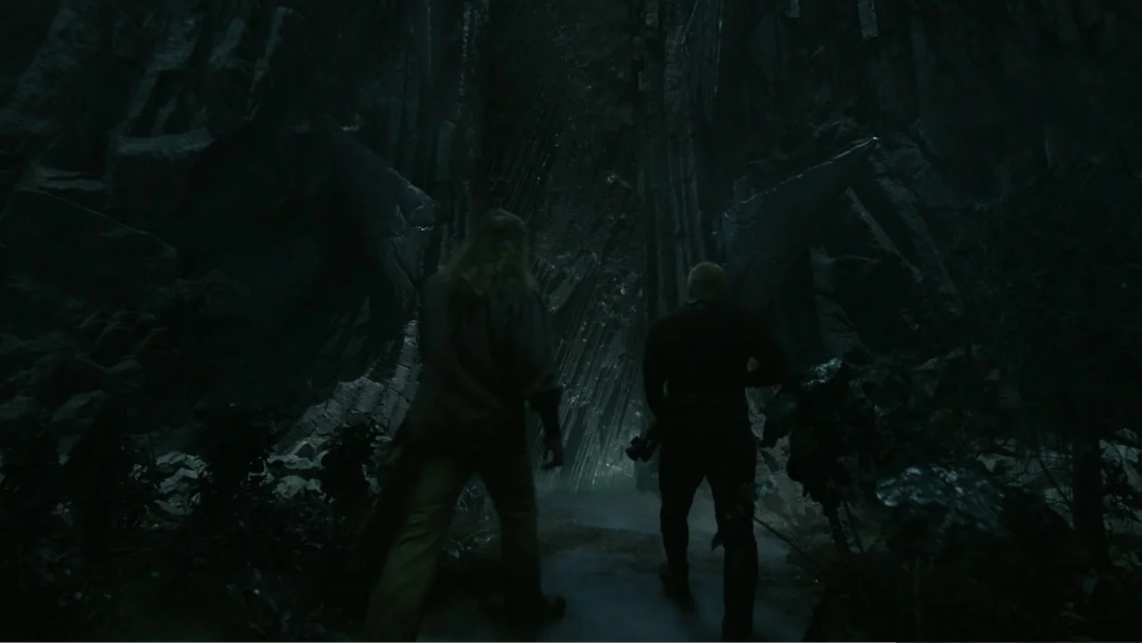 Aquaman and the Lost Kingdom (2023) movie still: wide — A dark narrow passage surrounded by sharp black volcanic rock formations at night. Two…