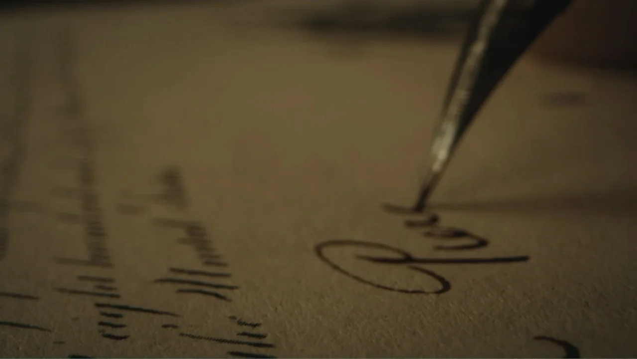 Demon in the White House (2021) movie still: closeup — A close view of an old parchment document with handwritten cursive ink text. A metal…