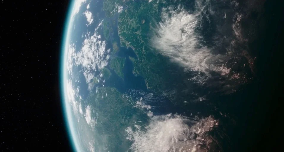 The Mandalorian (2019) movie still: establishing — A view of a planet from space showing dense forests and large water bodies. White clouds scatter…
