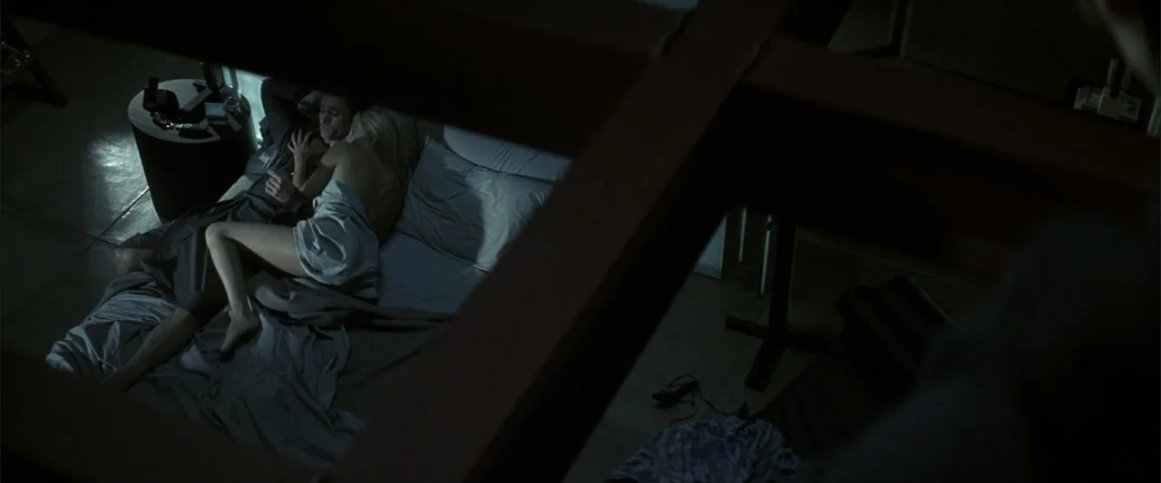 Enough (2002) movie still: wide — A dark, modern interior features a low-angle view looking down into a bedroom space. A man and a woman lie…