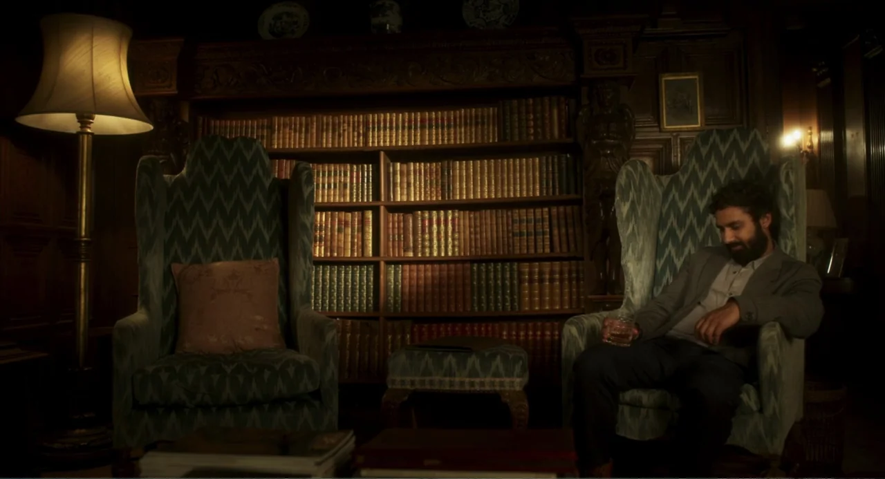 How to Date Billy Walsh (2024) movie still: medium — A wood-paneled library contains wall-to-wall bookshelves filled with aged, leather-bound books.…