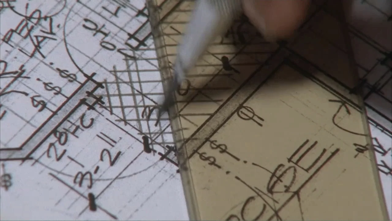 Temple Grandin (2010) movie still: closeup — A close-up of a technical blueprint on a desk with handwritten notes and symbols. A hand holding a…