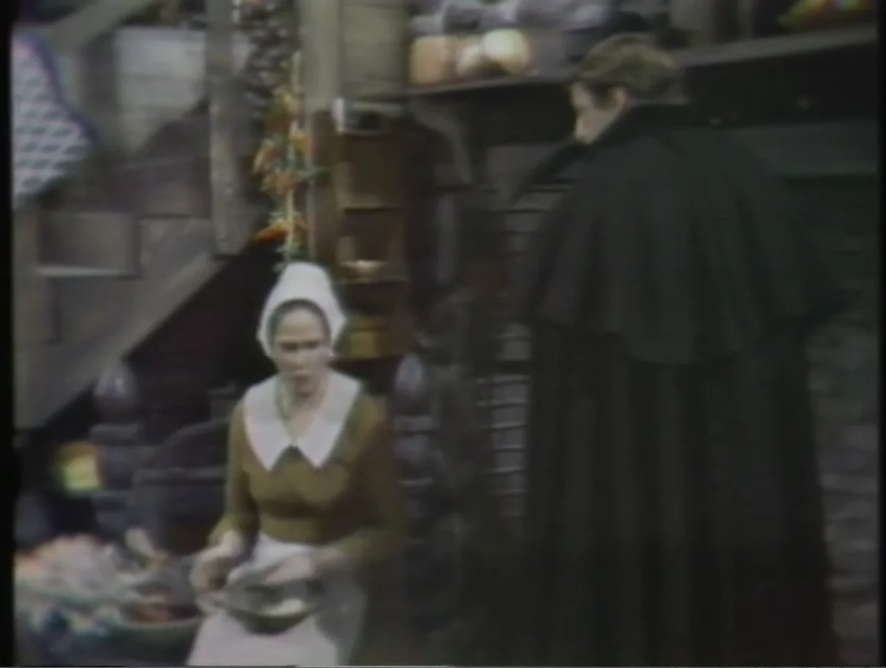 The Crucible (1996) movie still: medium — A dark wooden room features a rough-hewn interior with exposed timber walls. A woman in period-appropriate…