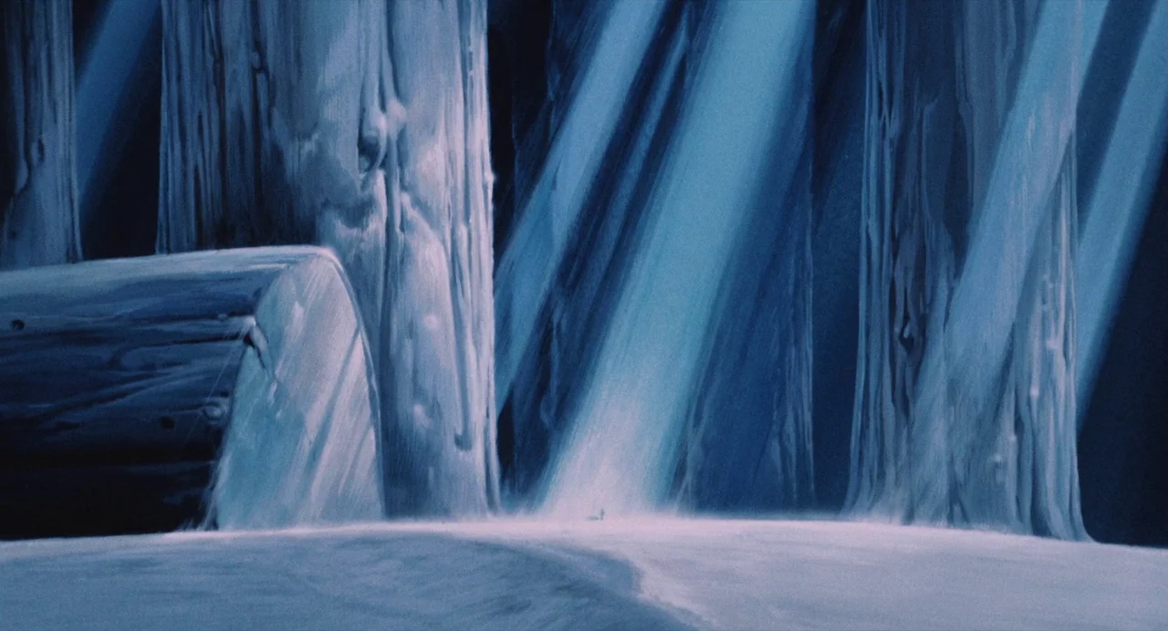 Nausicaä of the Valley of the Wind (1984) movie still: wide — Large, pale tree trunks rise from a flat, snow-covered surface under dark night skies.…