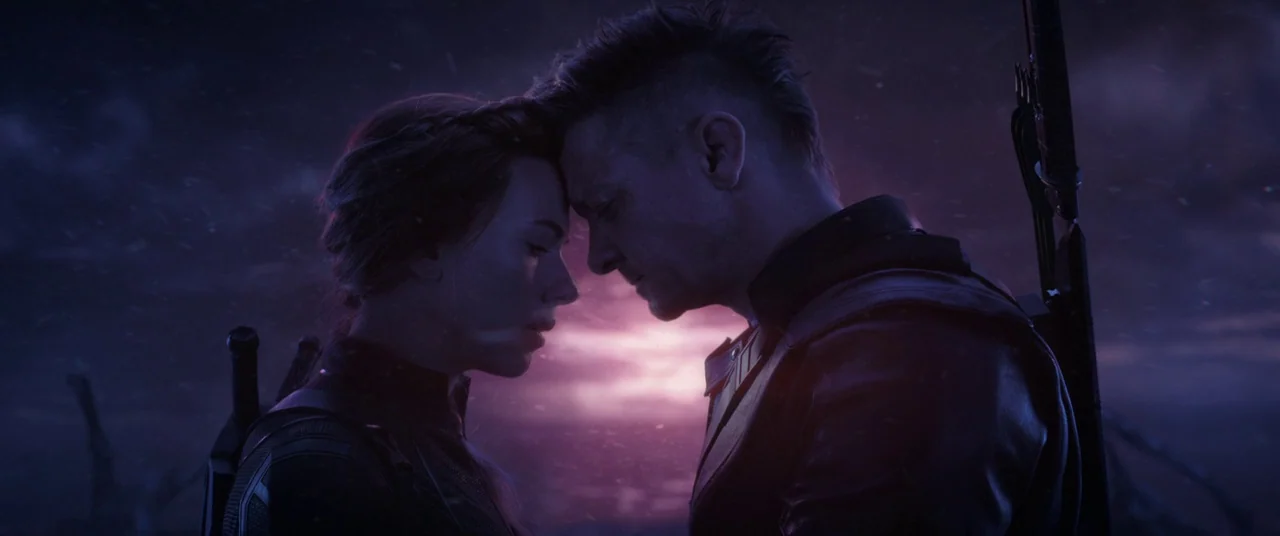 Avengers: Endgame (2019) movie still: medium — A dark, desolate alien landscape is silhouetted against a vibrant, purple and magenta dusk sky. A man…