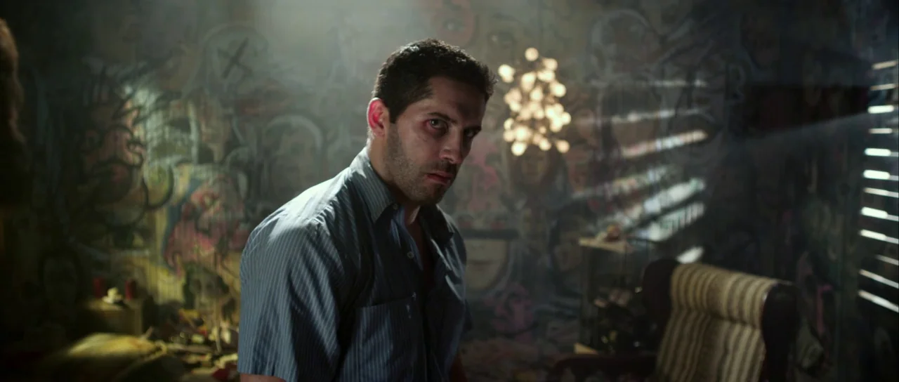 Universal Soldier: Day of Reckoning (2012) movie still: medium — A cluttered room features walls covered in intricate graffiti murals and a striped…
