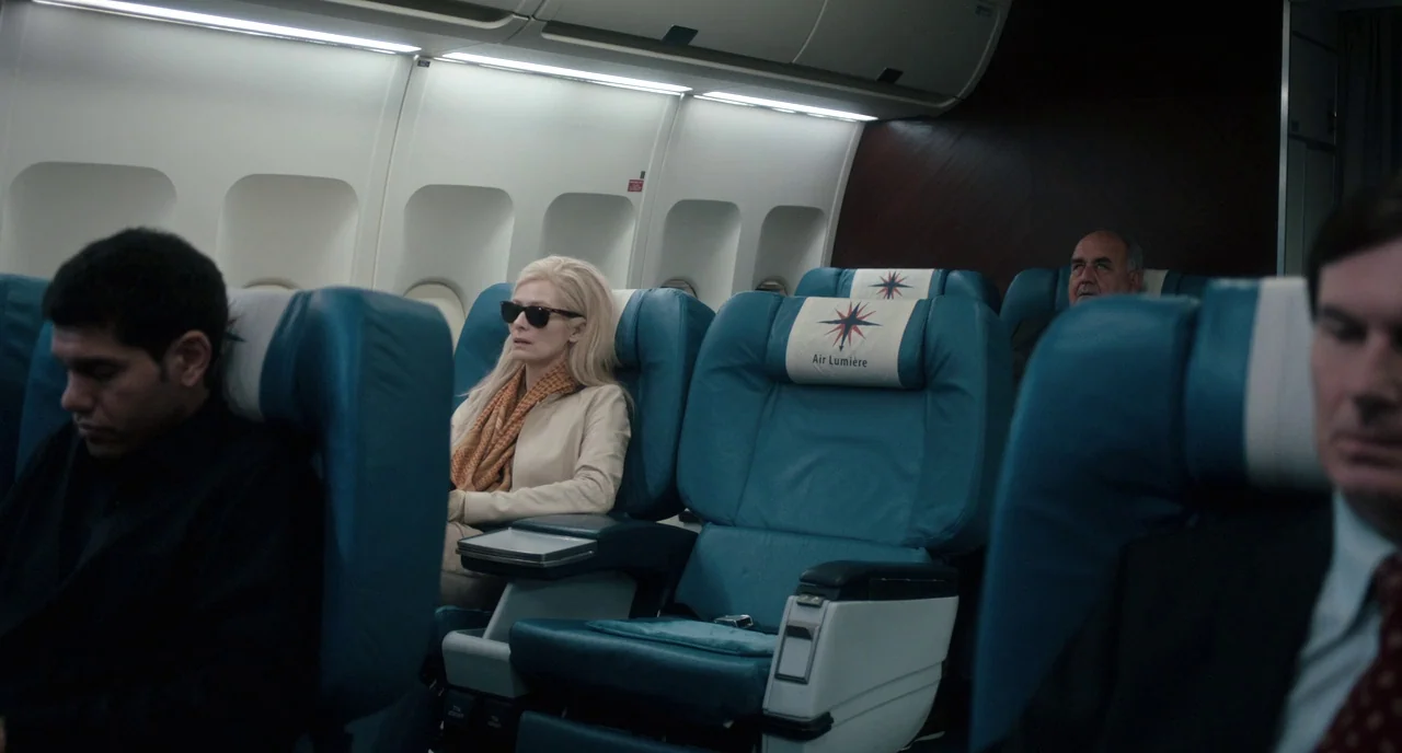 Only Lovers Left Alive (2013) movie still: medium — Passengers occupy teal-colored chairs inside the narrow, brightly lit cabin of an airliner. A…