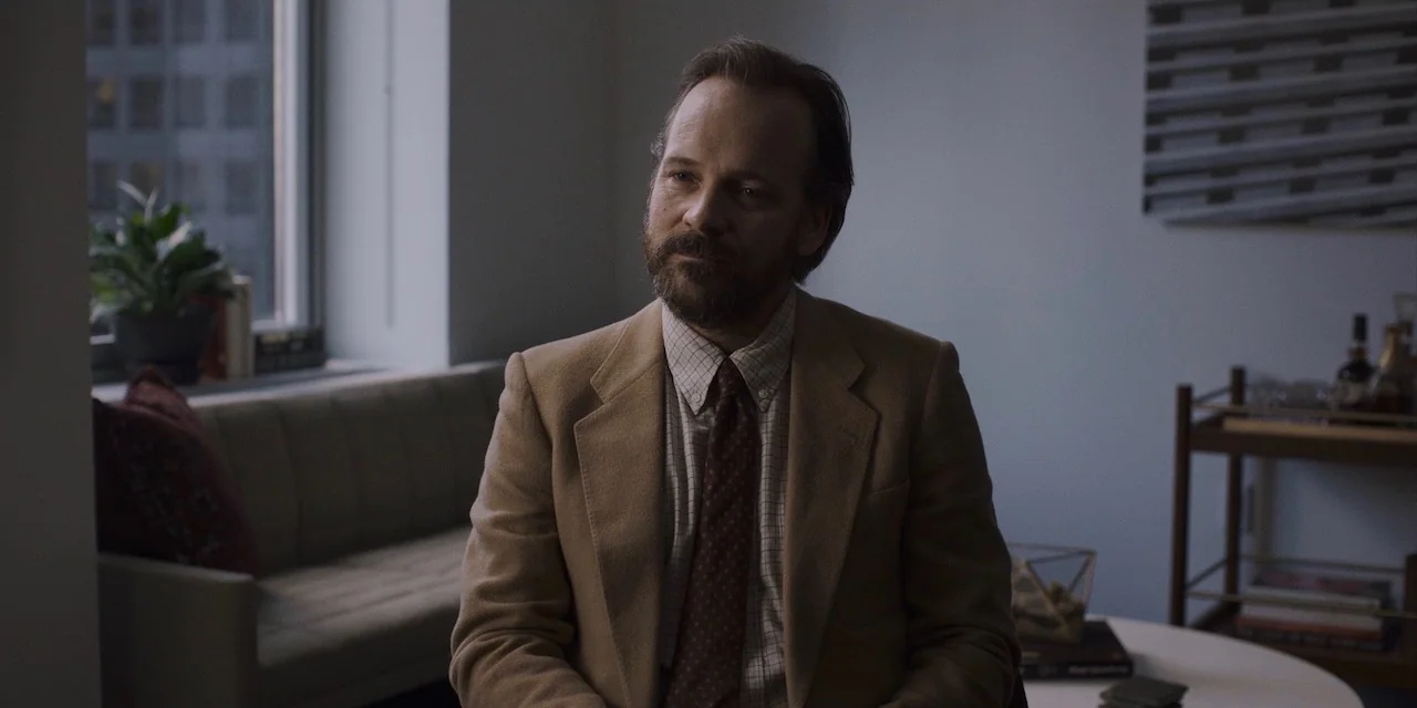 The Sound of Silence movie still: medium — An office interior features light blue walls, a window with a city view, and furniture. A man in a tan…