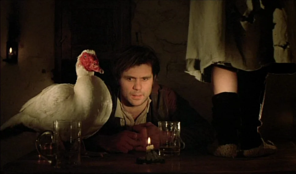 Heart of Glass (1976) movie still: medium — A dim room features a wooden table with a candle and two drinking glasses. A man sits at the table with…