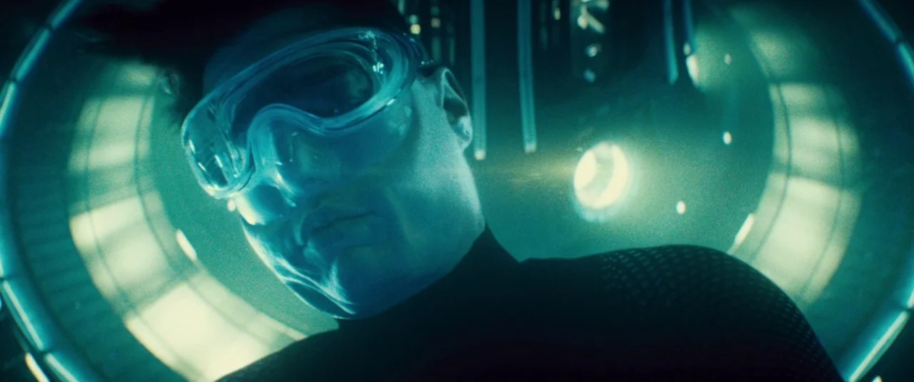 Mission: Impossible – Rogue Nation (2015) movie still: closeup — A dark, circular chamber features metallic surfaces and a glowing blue portal…