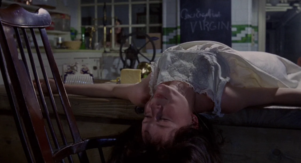 Secret Ceremony (1968) movie still: medium — A pantry room contains a wooden counter and a dark wall with chalk text. A woman in a white nightgown…