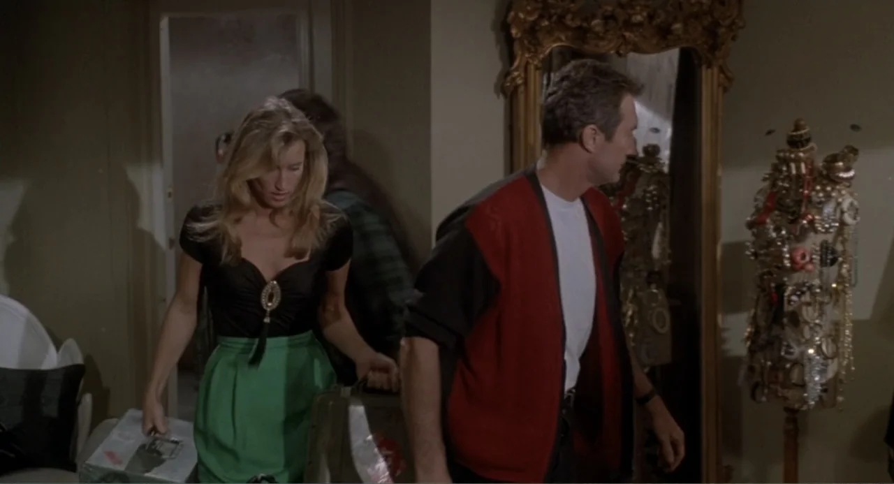 F/X2 (1991) movie still: medium — A furnished bedroom interior features a standing jewelry display and a large ornate mirror. A blonde woman and a…