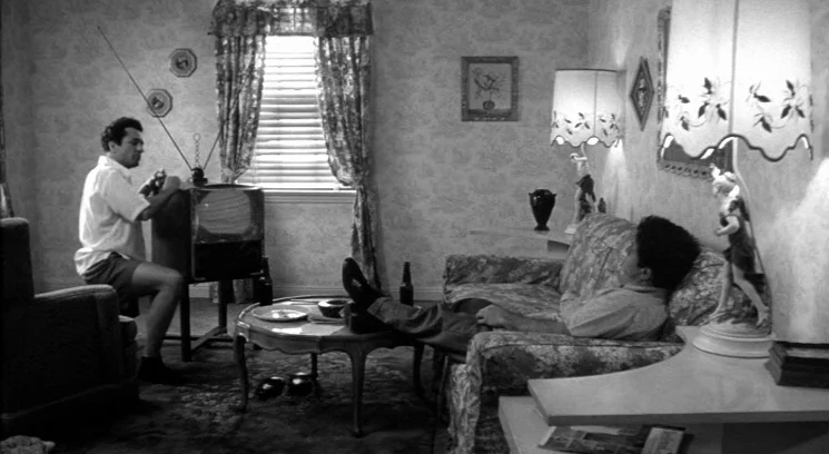 Raging Bull (1980) movie still: medium — A 1950s living room features patterned wallpaper, a television set, and floral upholstered furniture. One…