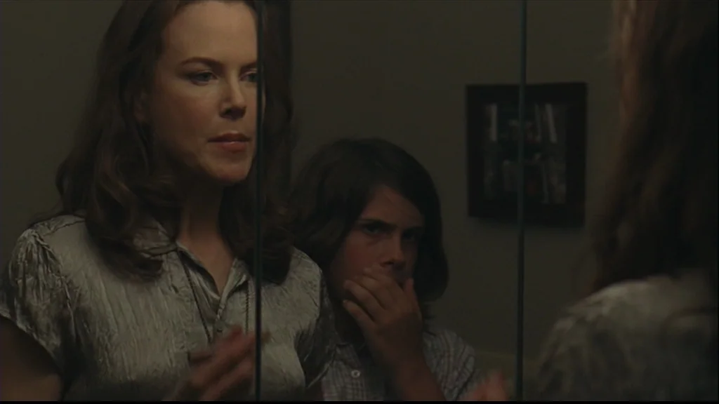 Margot At The Wedding (2007) movie still: medium — A dimly lit room features a woman and child viewed through a mirror. The mirror's reflection…