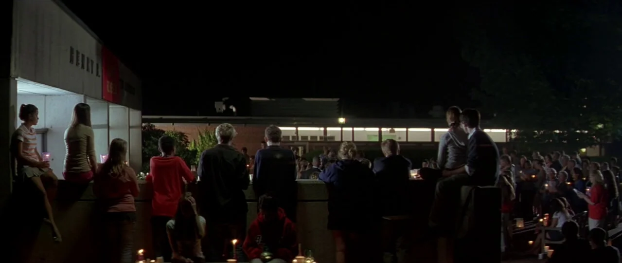 Afterschool (2008) movie still: wide — A nighttime scene shows a group of teenagers sitting on a low concrete wall. They are gathered for a…