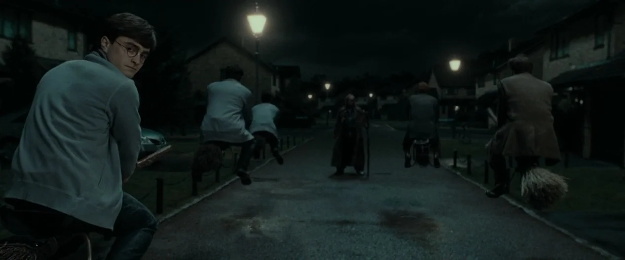 Harry Potter & The Deathly Hallows Part 1 (2010) movie still: wide — A dark residential street is lined with houses and illuminated by vintage…