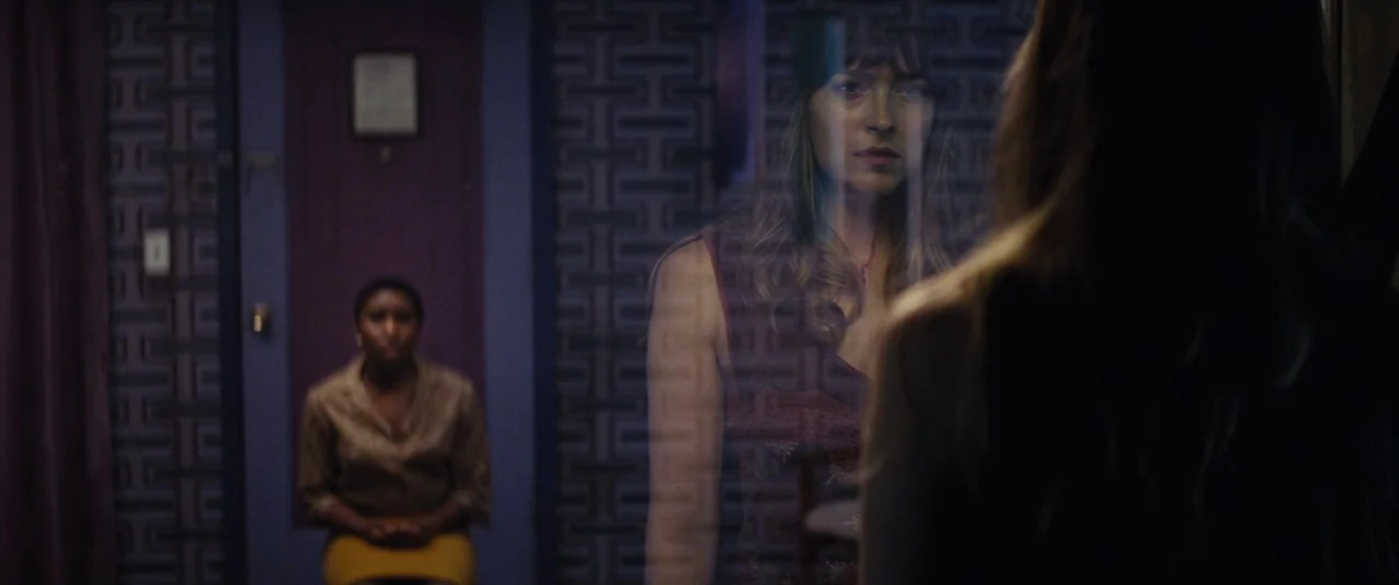 Bad Times at the El Royale (2018) movie still: medium — An interior space features patterned dark wallpaper and a reflective glass partition. One…