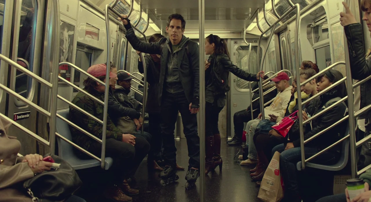 While We’re Young (2014) movie still: wide — A crowded public transit car features silver metal handrails and drab, functional interior panels. A…